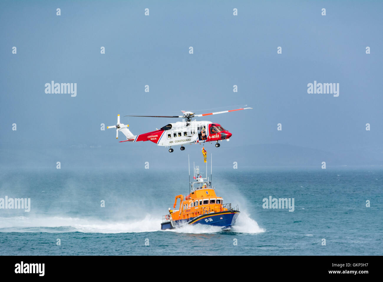 Mousehole, Cornwall, UK. 21st Aug, 2016. After a week of tragedies around the UK coast, and heroic rescues by the RNLI and the Coastguards, the Penlee Lifeboat and Coastguard helicopter display their skills for the annual fundrasing lifeboat day at Mousehole in Cornwall. Credit:  Simon Maycock/Alamy Live News Stock Photo