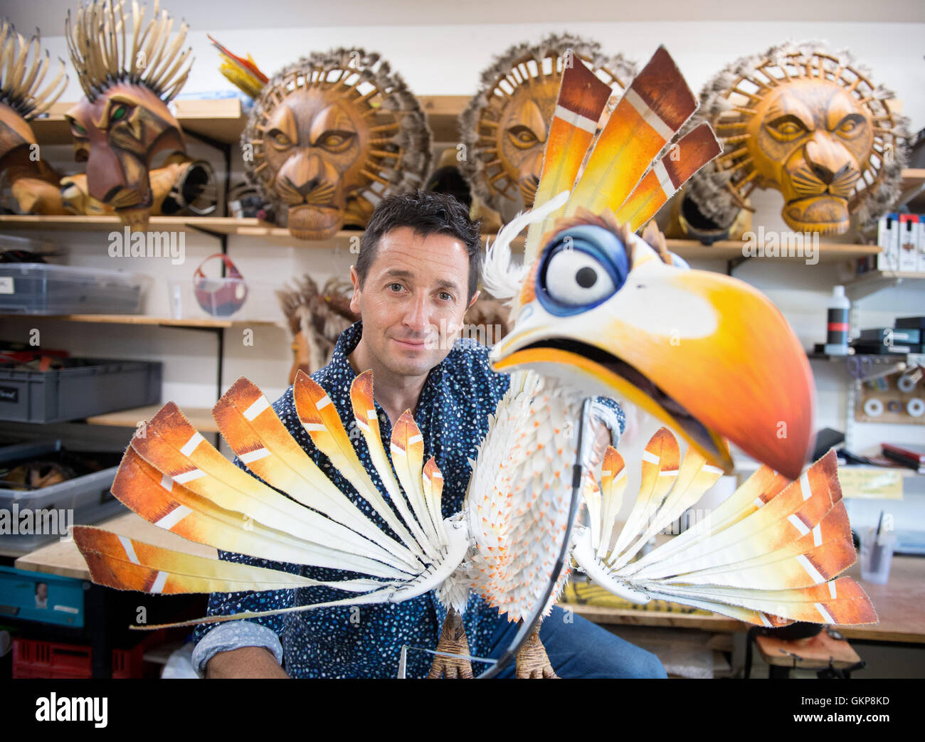 Hamburg, Germany. 10th Aug, 2016. Joachim Benoit, performer in the musical The Lion King poses with a puppet of the bird Zazu, in the Theater im Hafen in Hamburg, Germany, 10 August 2016. Benoit has been playing the role of the cheeky bird Zazu in the Hamburg staging of the musical The Lion King for 15 years. PHOTO: DANIEL REINHARDT/DPA/Alamy Live News Stock Photo