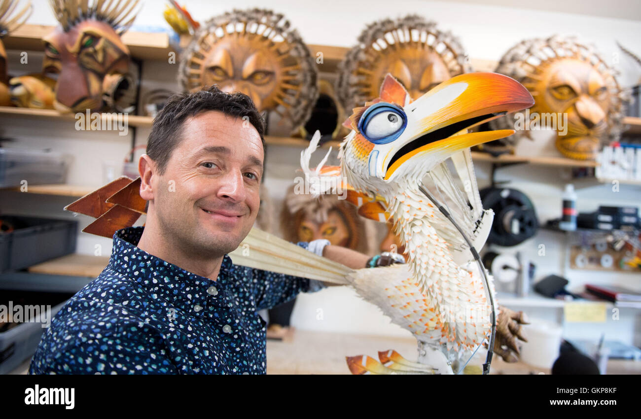 Hamburg, Germany. 10th Aug, 2016. Joachim Benoit, performer in the musical The Lion King poses with a puppet of the bird Zazu, in the Theater im Hafen in Hamburg, Germany, 10 August 2016. Benoit has been playing the role of the cheeky bird Zazu in the Hamburg staging of the musical The Lion King for 15 years. PHOTO: DANIEL REINHARDT/DPA/Alamy Live News Stock Photo