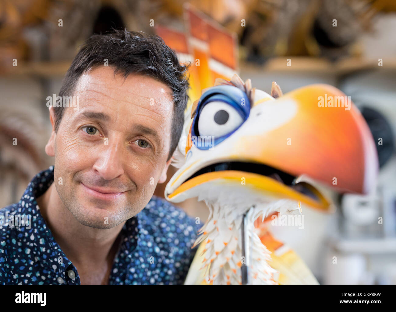 Hamburg, Germany. 10th Aug, 2016. Joachim Benoit, performer in the musical The Lion King poses with a puppet of the bird Zazu, in the Theater im Hafen in Hamburg, Germany, 10 August 2016. Benoit has been playing the role of the cheeky bird Zazu in the Hamburg staging of the musical The Lion King for 15 years. PHOTO: DANIEL REINHARDT/DPA/Alamy Live News Stock Photo