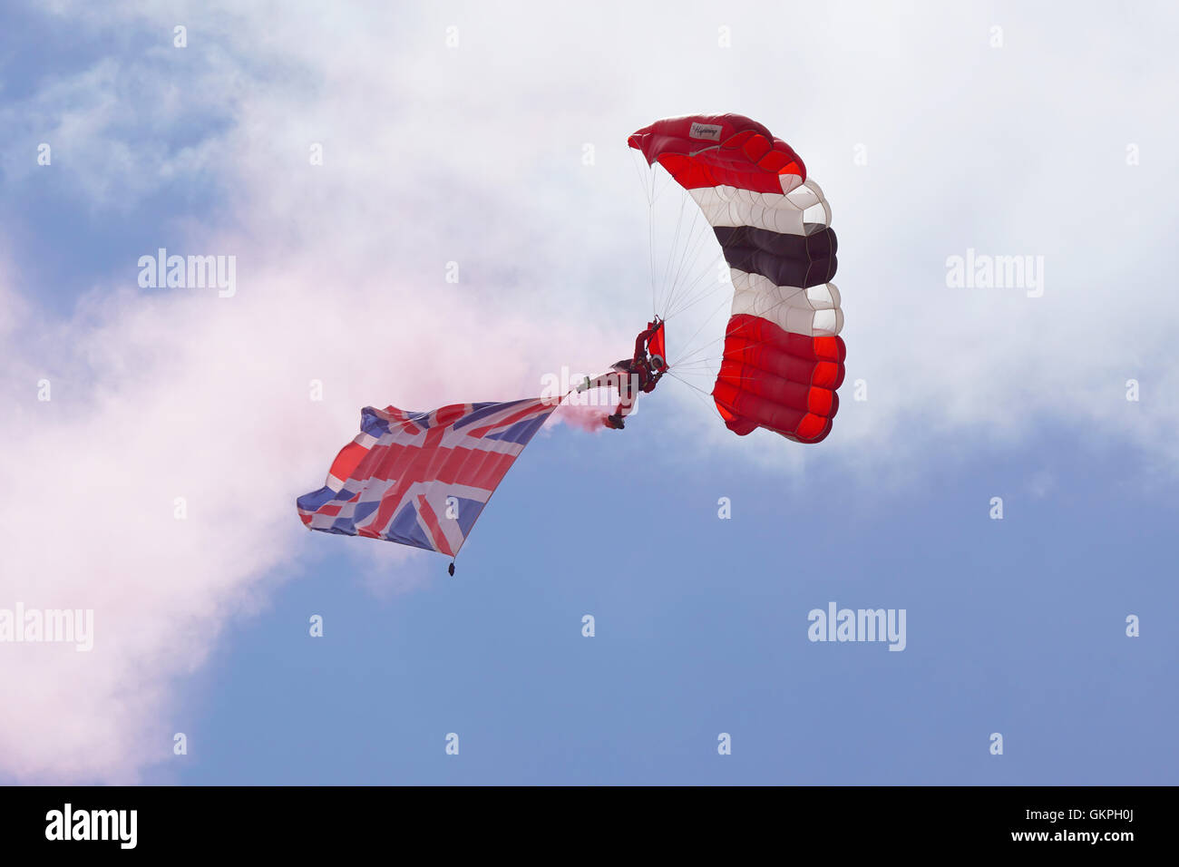 A member of The Parachute Regiment's elite Red Devils display team descends with a Union flag during a demonstration Stock Photo