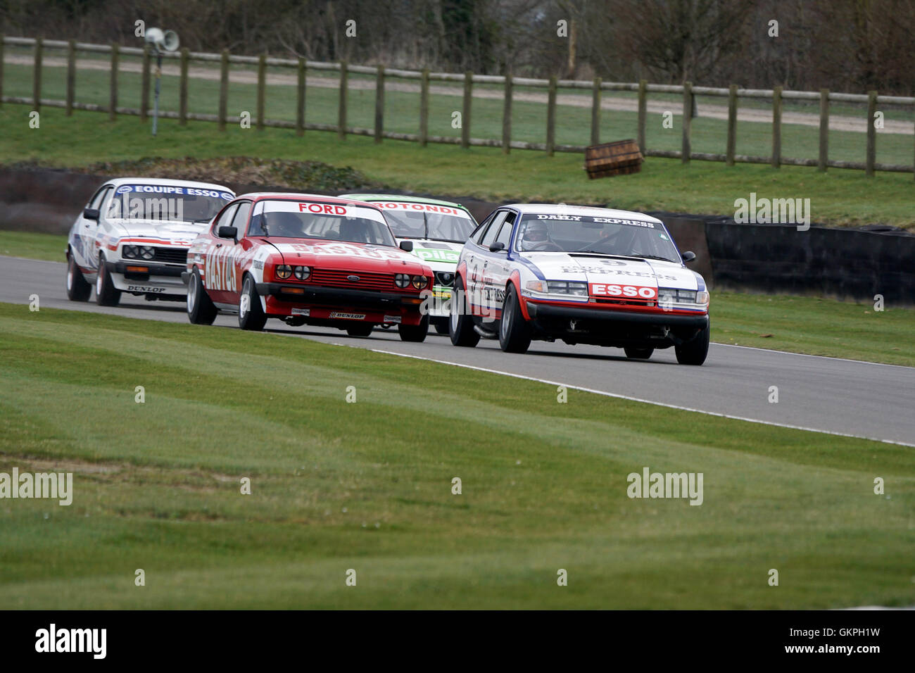 A gaggle of 70's saloon cars cornering hard during the Goodwood Members Meeting Stock Photo