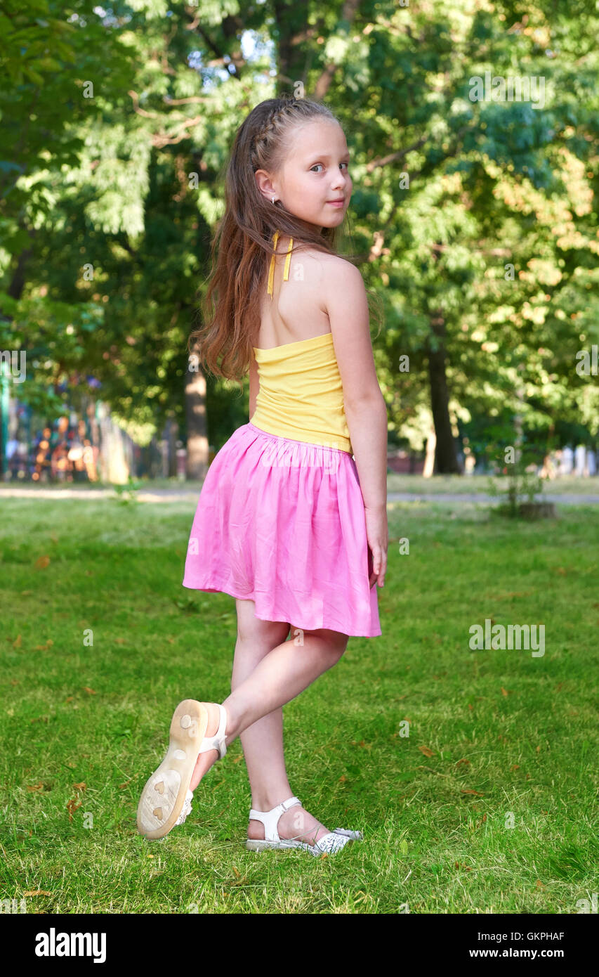 happy child girl dressed in casual cloth posing, childhood concept, summer season in city park Stock Photo