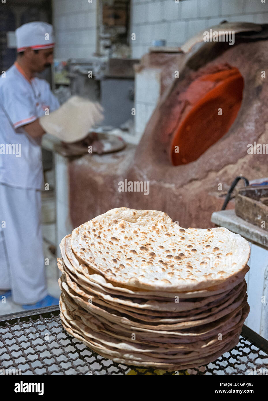 Persian baker baking beautiful Persian Taftoon Bread using tandoor oven