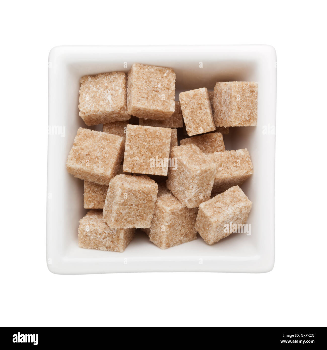 Brown sugar cubes in a square bowl isolated on white background Stock