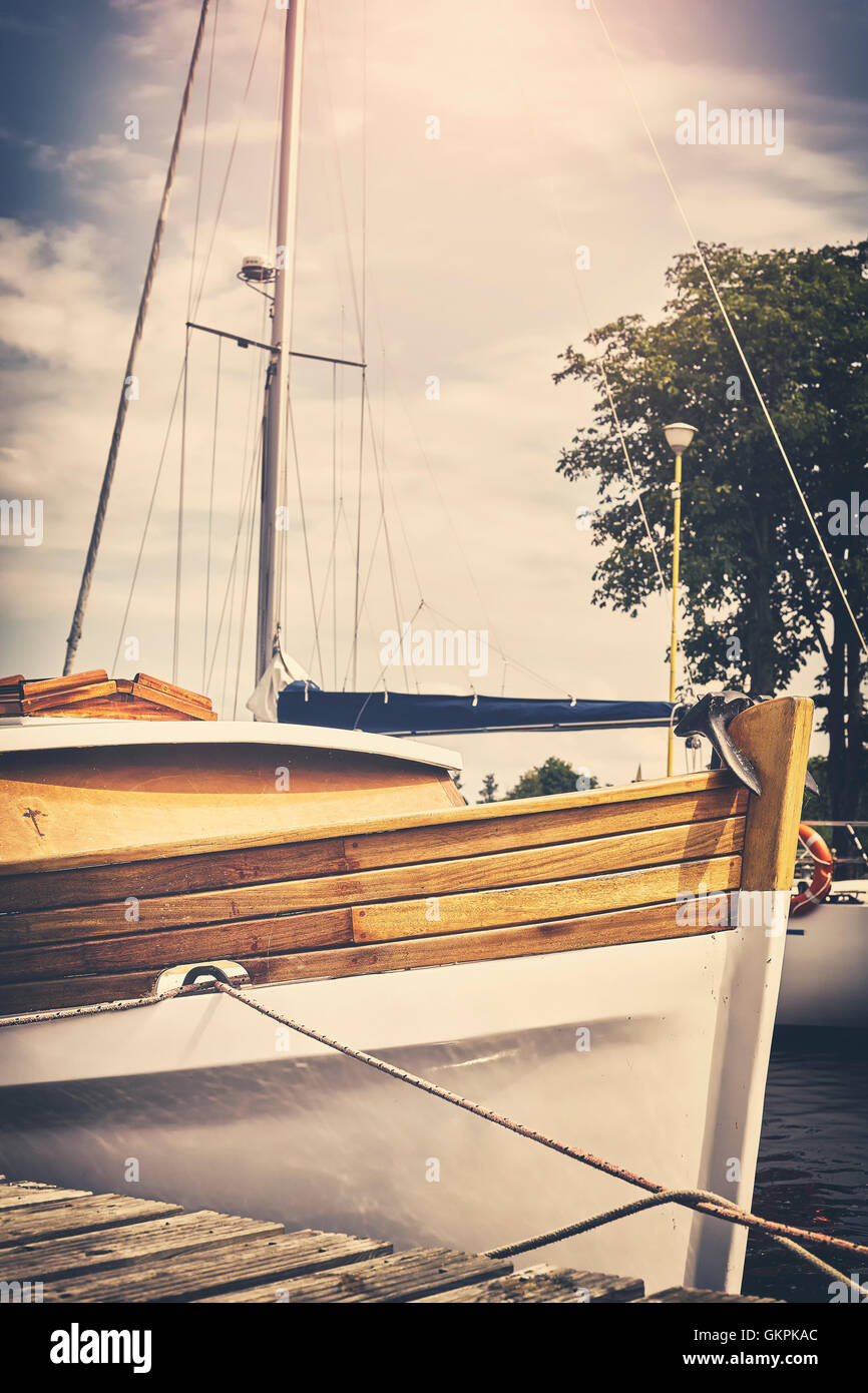 Vintage old film toned wooden boat moored to a pier in marina Stock ...