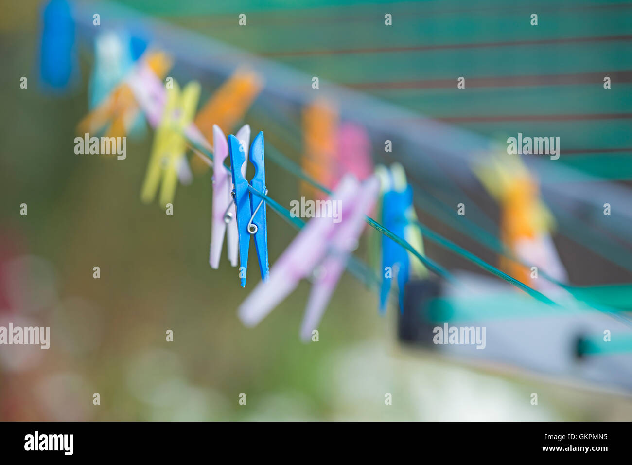 Brightly coloured clothes pegs on a rotary washing line. Stock Photo