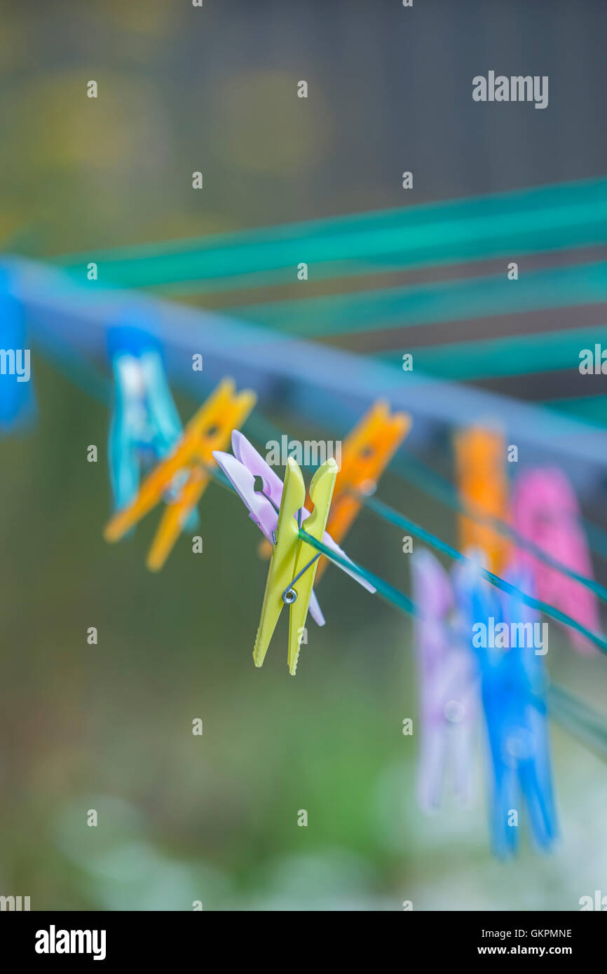 Brightly coloured clothes pegs on a rotary washing line. Stock Photo