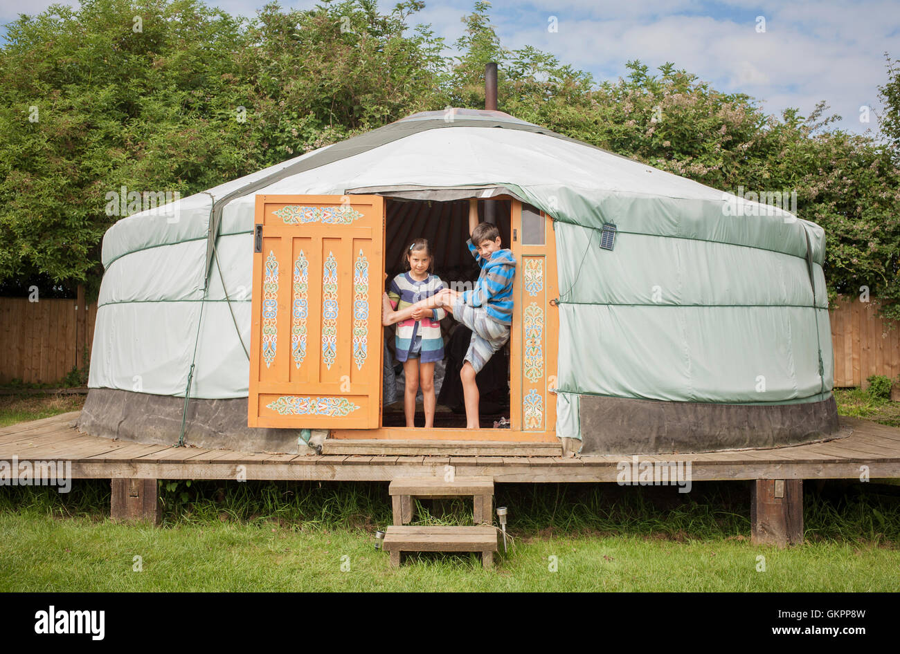 Two children in doorway of yurt on holiday Stock Photo