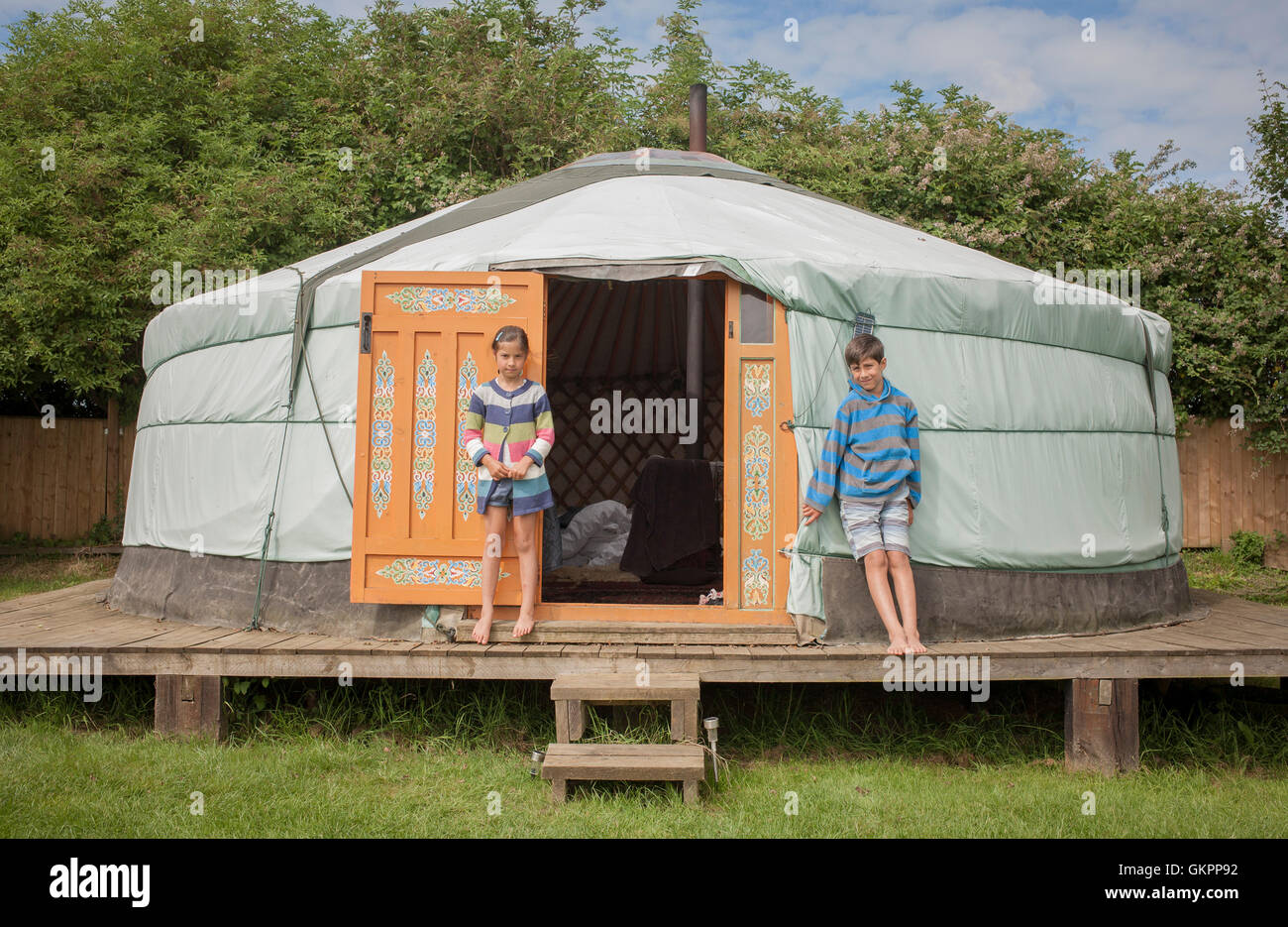 Two children standing outside yurt on holiday Stock Photo
