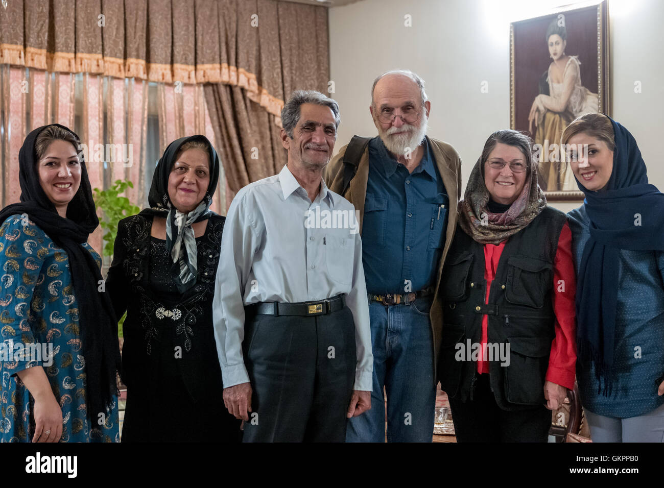 Narsrin Bateni is an award winning miniaturist specializing in traditional Persian miniature paintings in her workshop in Isfahan, Iran.  Narsrin with her family and customers in her home. Stock Photo