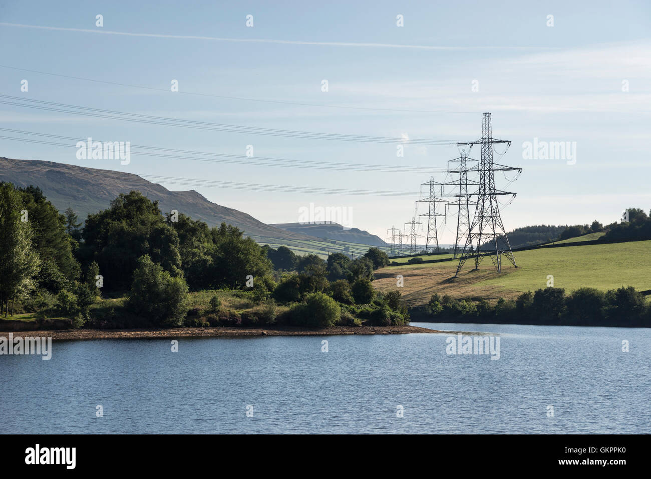 Pylons beside the reservoirs in the Longdendale valley, northern England. View across Bottom's reservoir on a summer morning. Stock Photo