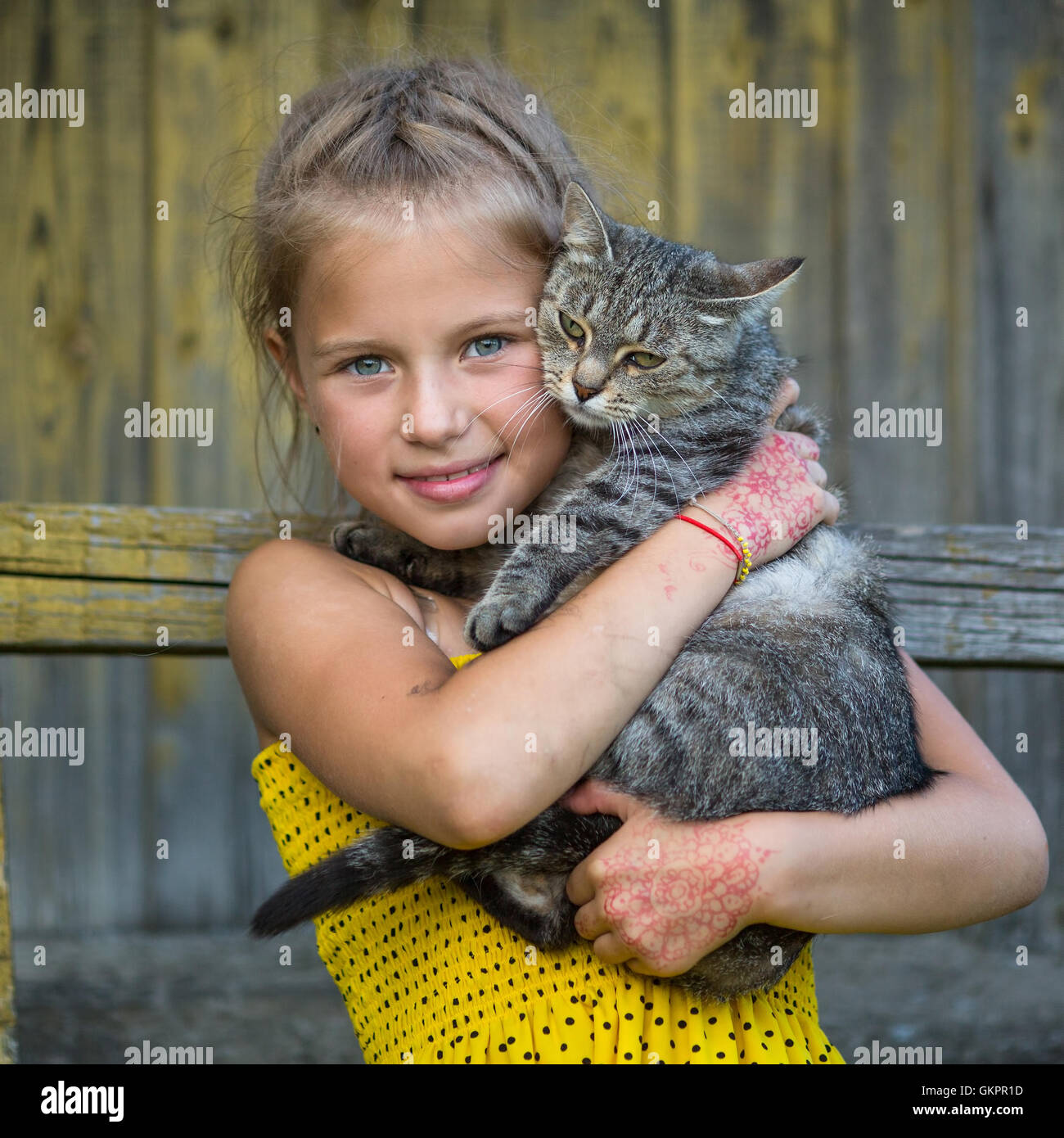 Funny little girl holding a cat in her arms Stock Photo Alamy
