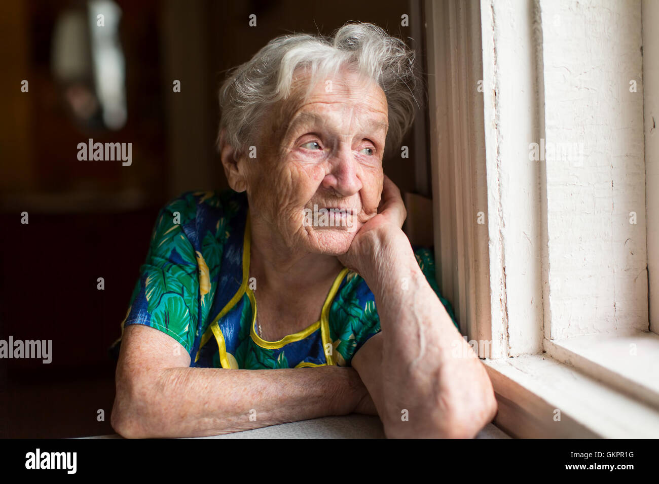 Grandma looks out the window. Old age, loneliness Stock Photo Alamy