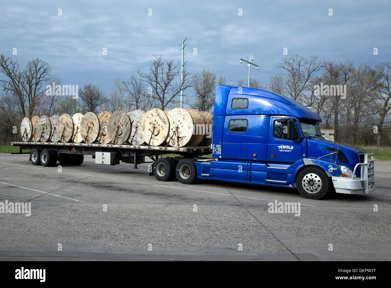 Large empty wire spools being transported on bed of semi truck at a