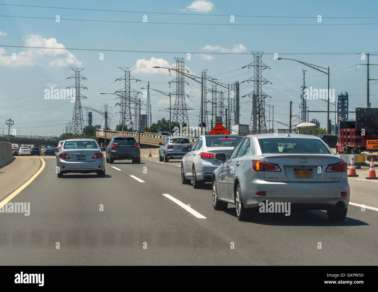 New Jersey Turnpike cars with electricity pylons and power lines along the road Stock Photo