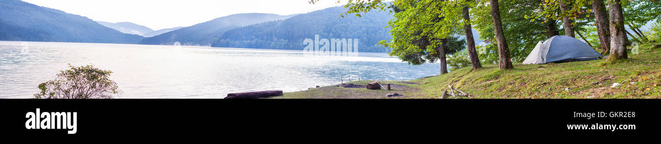 Camping tent on the bank of a lake panorama Stock Photo - Alamy