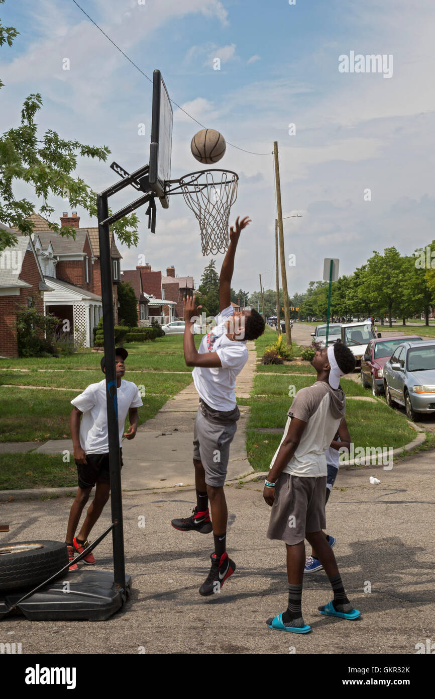 Detroit, Michigan - Teenage boys play basketball in the street during a summer street fair held by a neighborhood group. Stock Photo