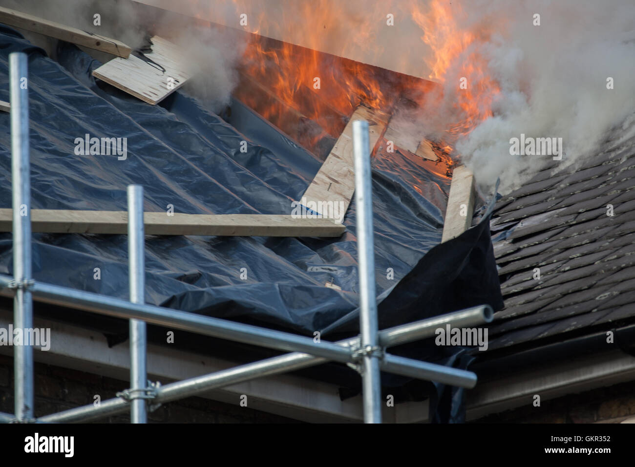 Fire breaks through the roof of a hotel under renovation in East London. Stock Photo