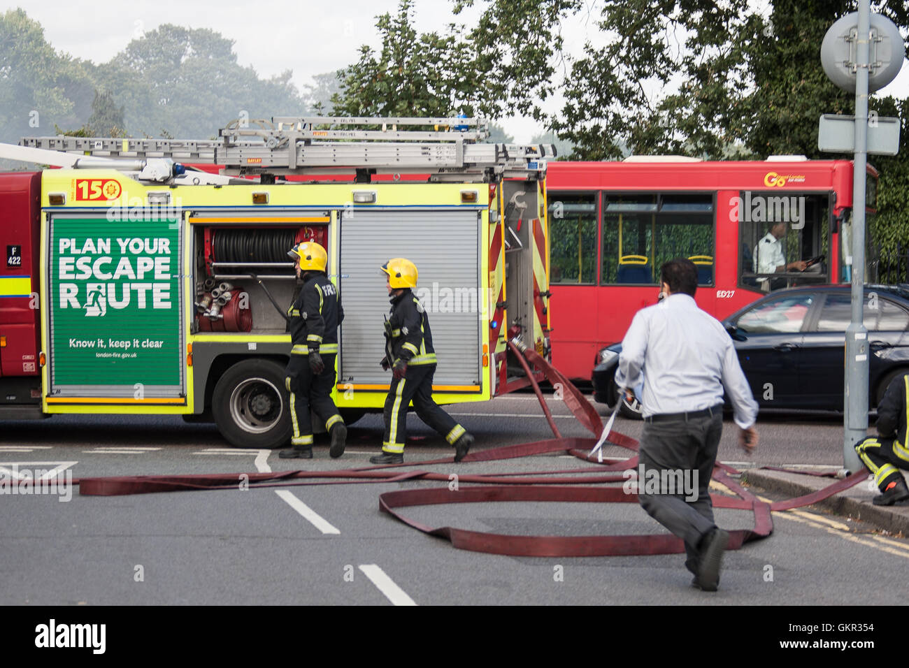 Firefighters setting up a water supply from a hydrant during a fire at