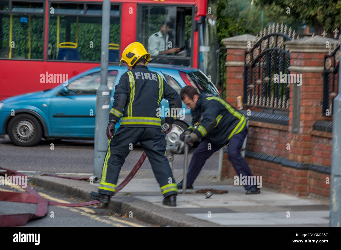 Firefighters setting up a water supply from a hydrant during a fire at