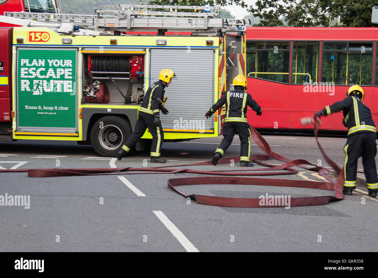 Firefighters setting up a water supply from a hydrant during a fire at a hotel in East London Stock Photo