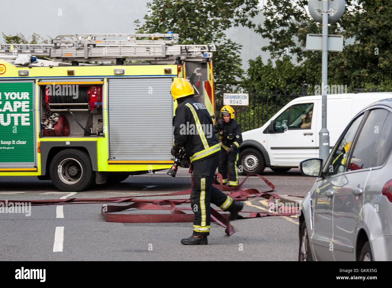 Firefighters setting up a water supply from a hydrant during a fire at