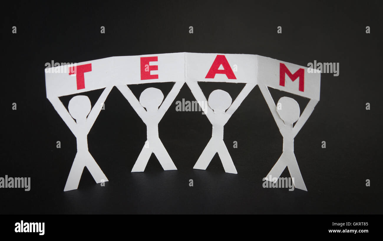 Paper silhouettes holding a Team sign Stock Photo