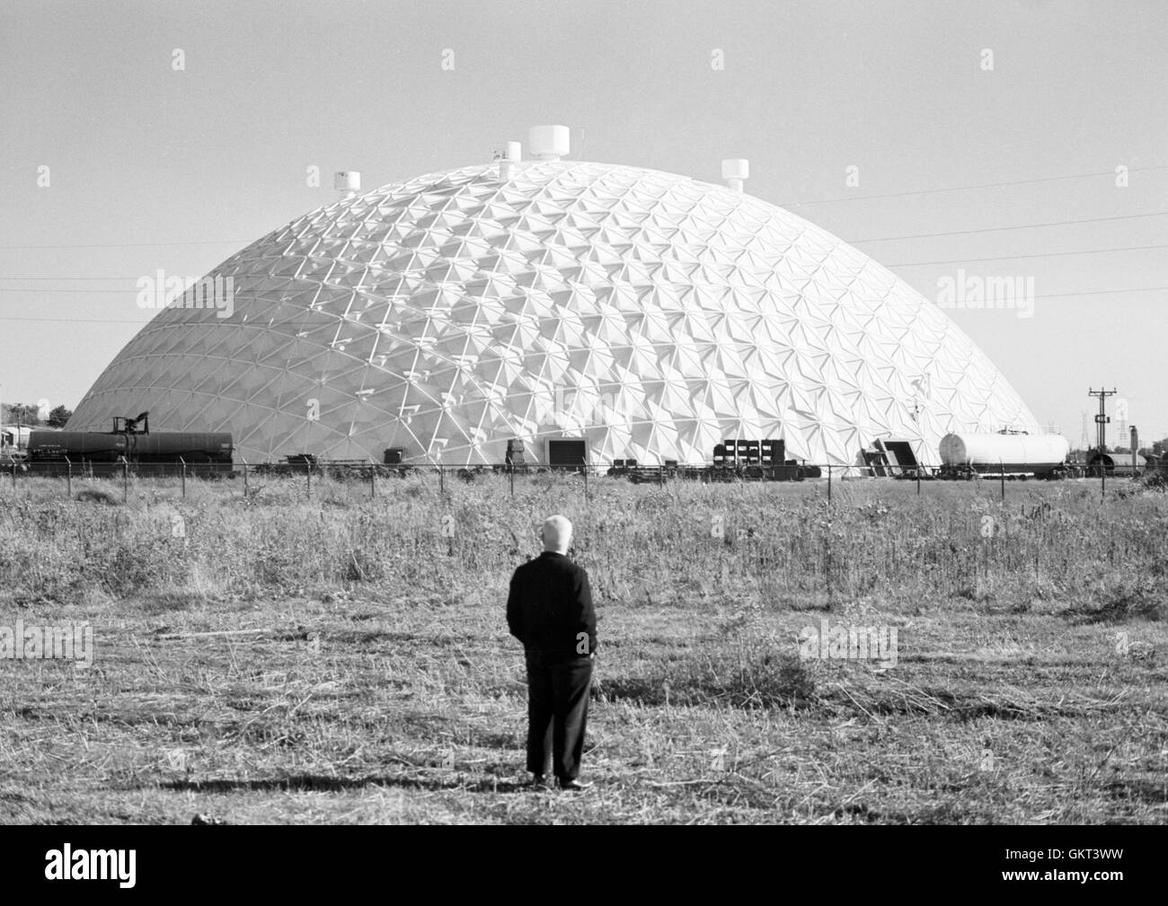 Buckminster Fuller standing near the hexdome structure of the