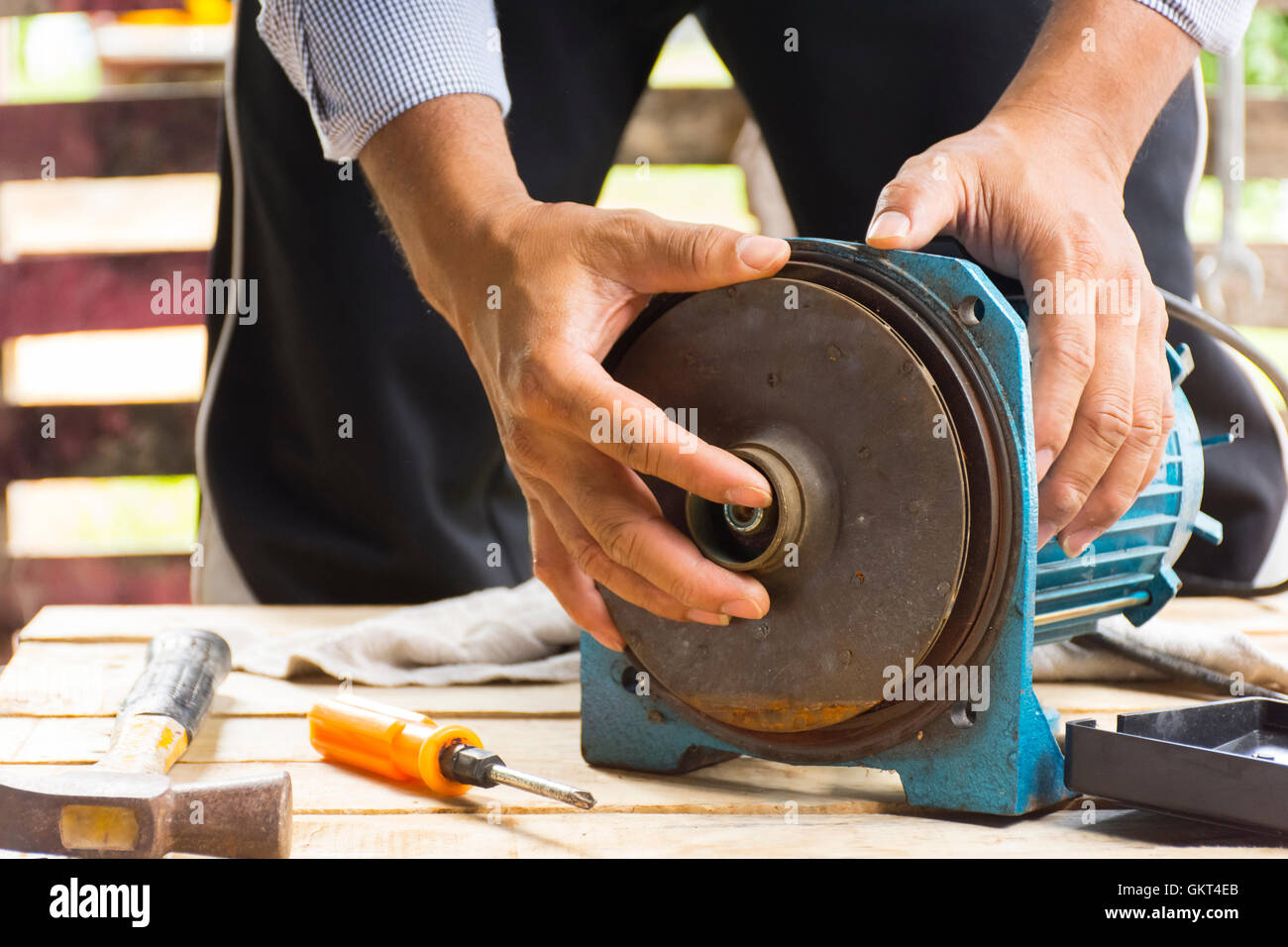 Electric motor and man working equipment repair on wooden floor