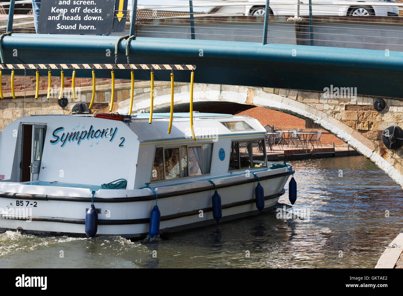 River cruiser passing under Wroxham Bridge. Norfolk Broads England UK Stock Photo