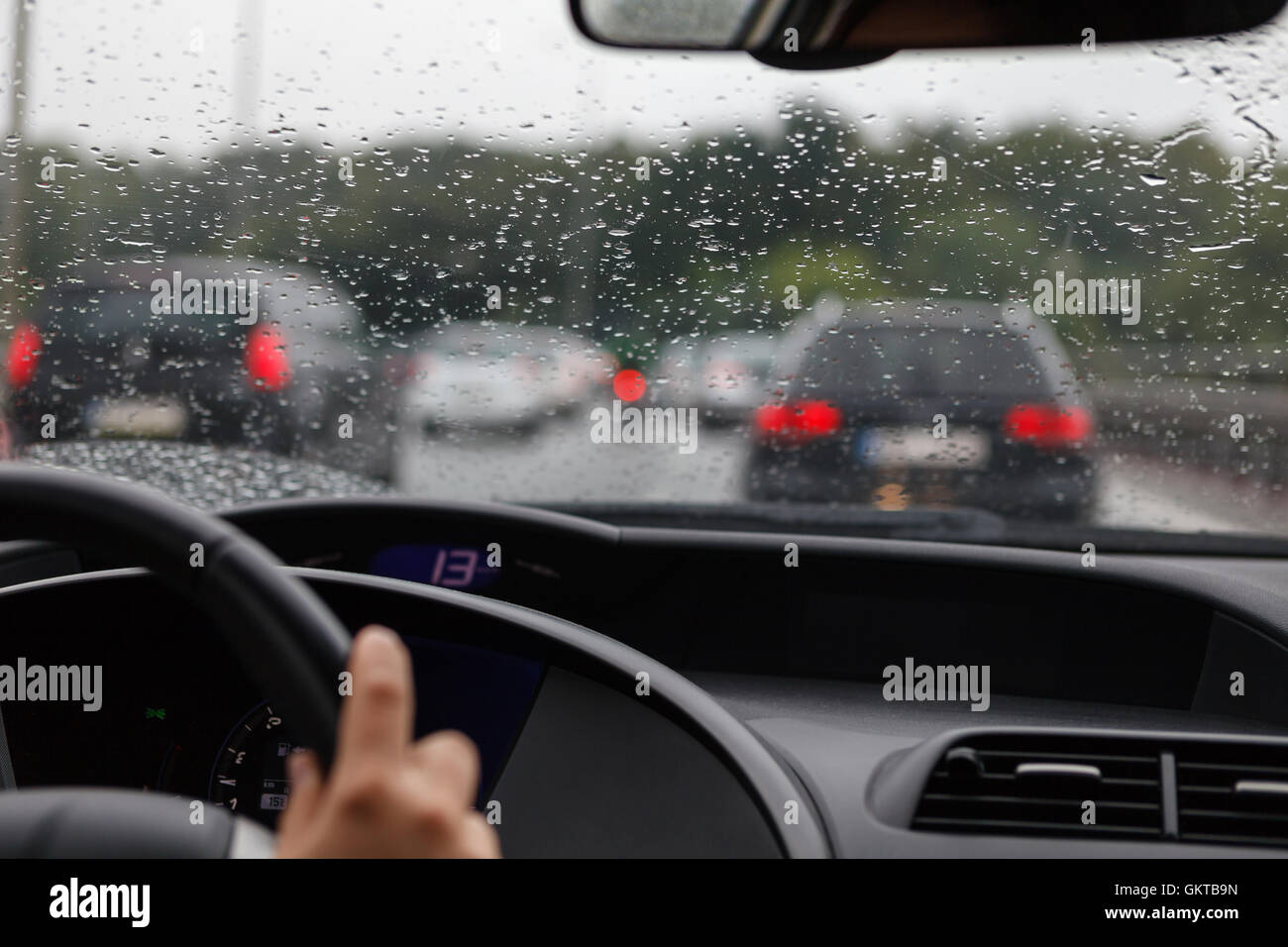 Driving a car in traffic jam in bad weather conditions, green and red lights Stock Photo