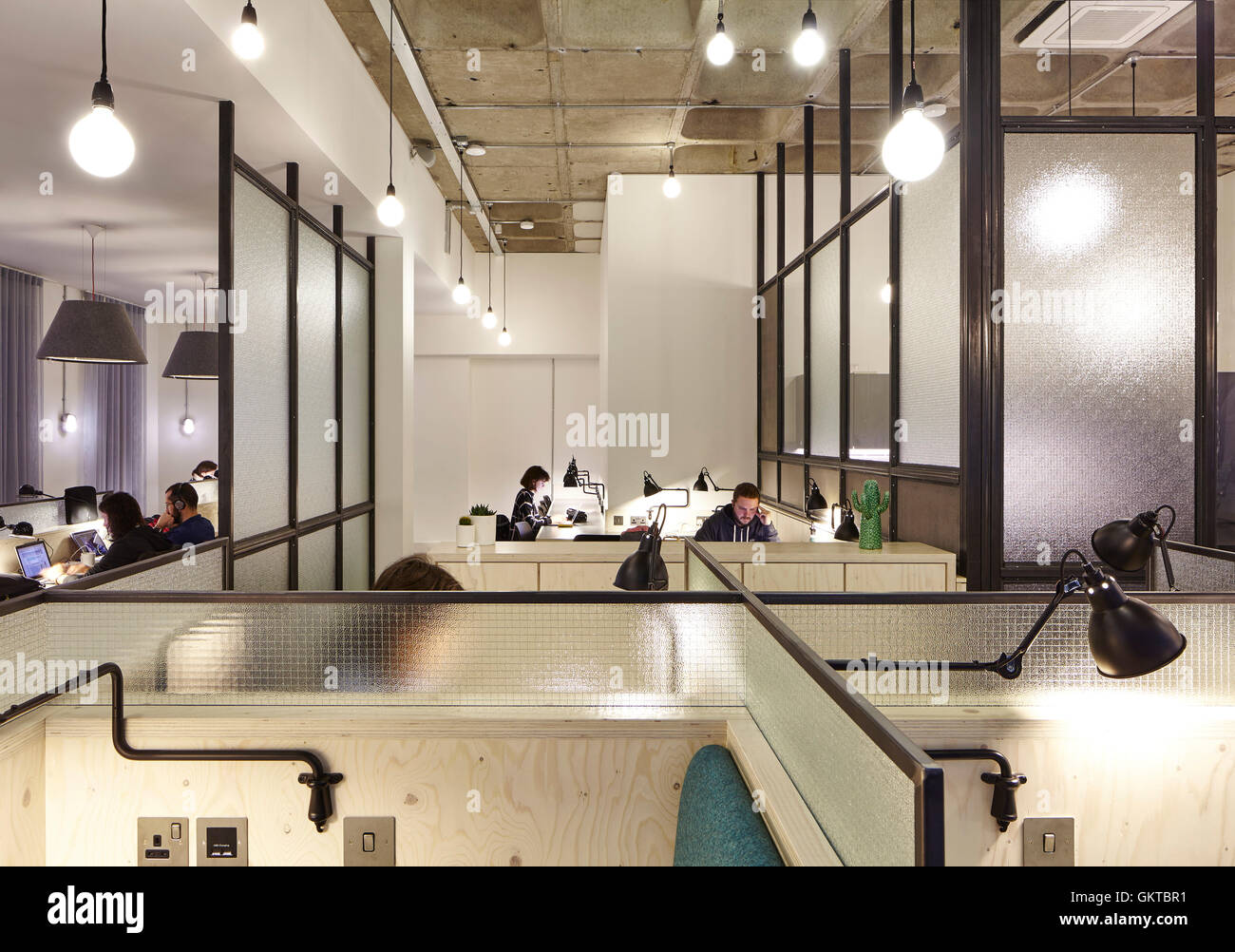 Work spaces with glass screens and people working. 201 Borough High Street, London, United Kingdom. Architect: Stiff + Trevillion Architects, 2016. Stock Photo