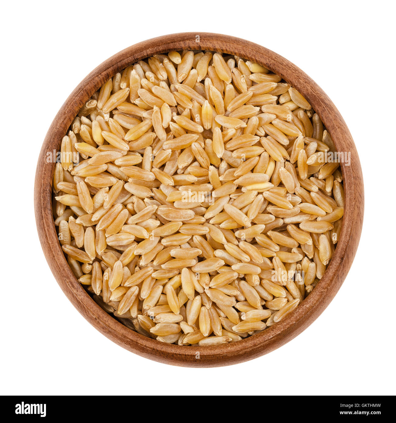 Kamut Khorasan wheat in a wooden bowl on white background. Grains of Oriental wheat, Triticum turanicum. Stock Photo