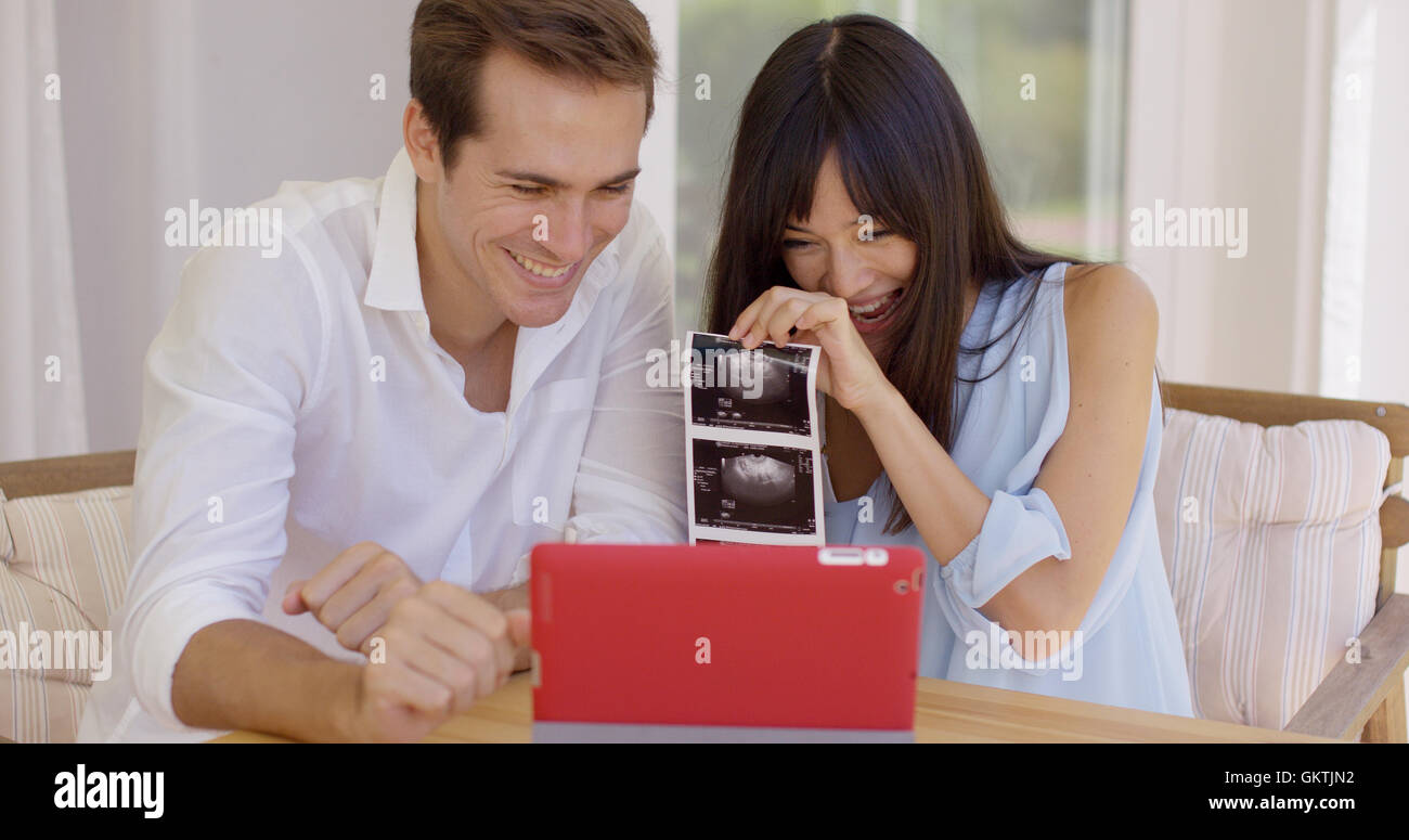 Blushing couple showing off ultrasound pictures Stock Photo