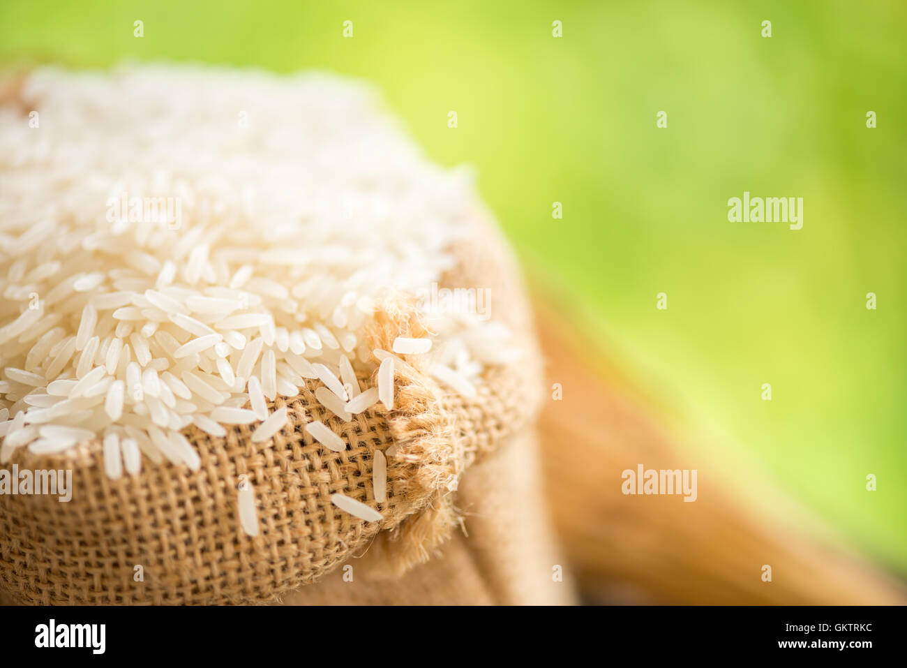 white rice in burlap sack with rice grain Stock Photo