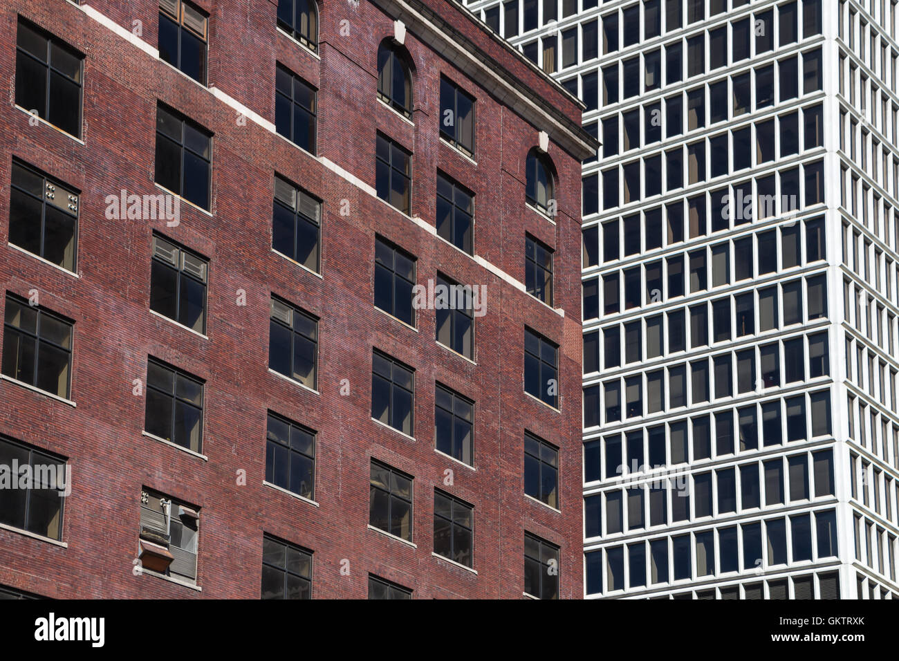 Side by side, old abandoned bricks building and modern white skyscraper. Detroit, Michigan, United States of America Stock Photo