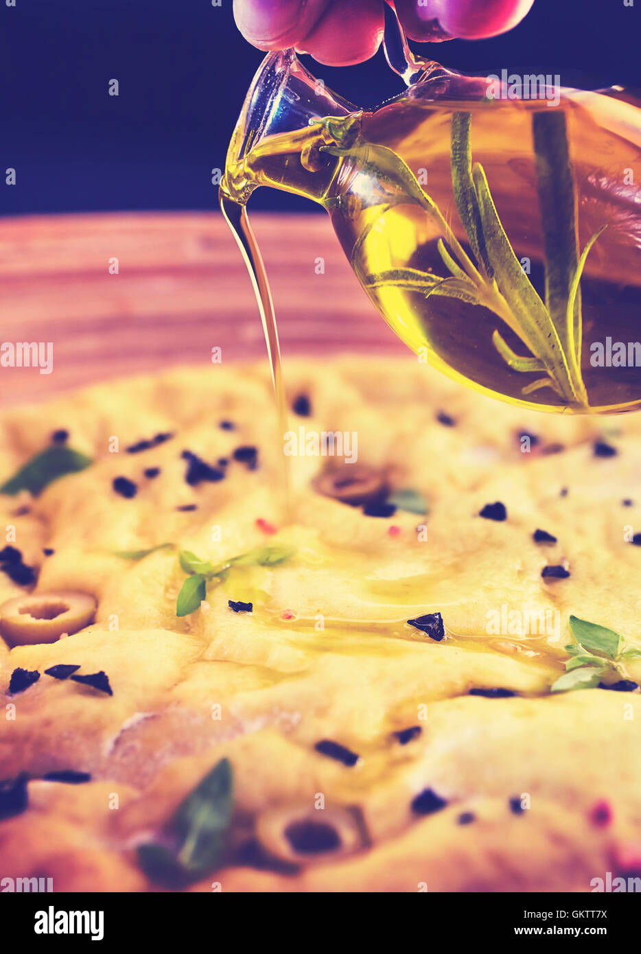 Pouring olive oil to yeast dough, vintage toned picture with shallow depth of field. Stock Photo