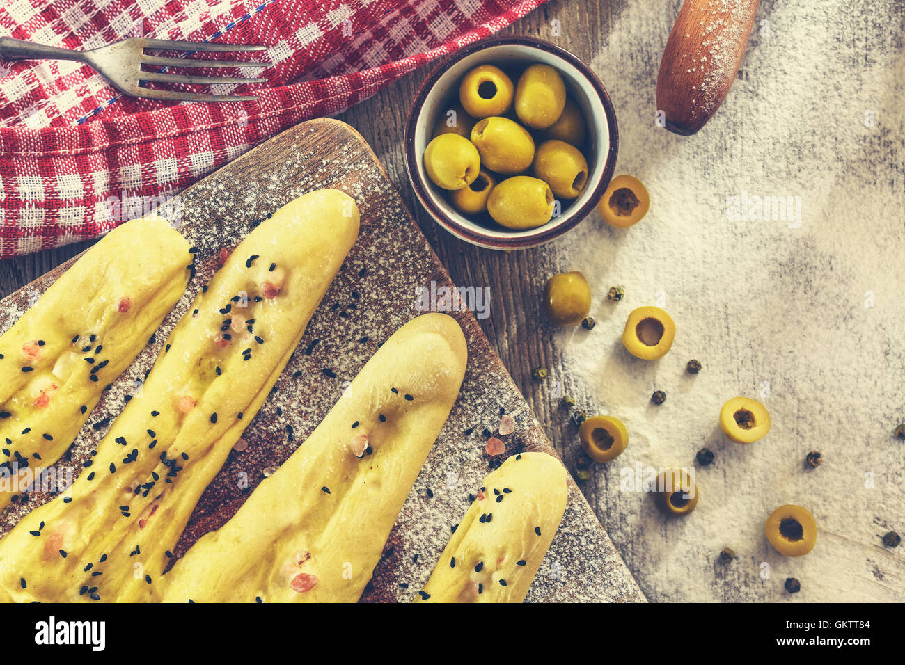 Bread sticks ready for baking, rustic setting on a wooden table. Stock Photo