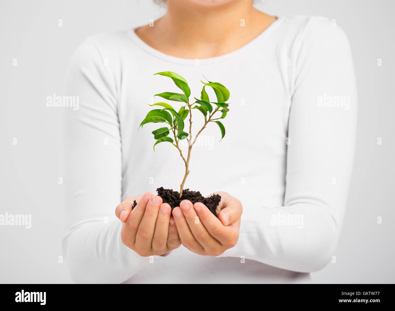 Cute little girl holding a green plant oh her hands Stock Photo - Alamy
