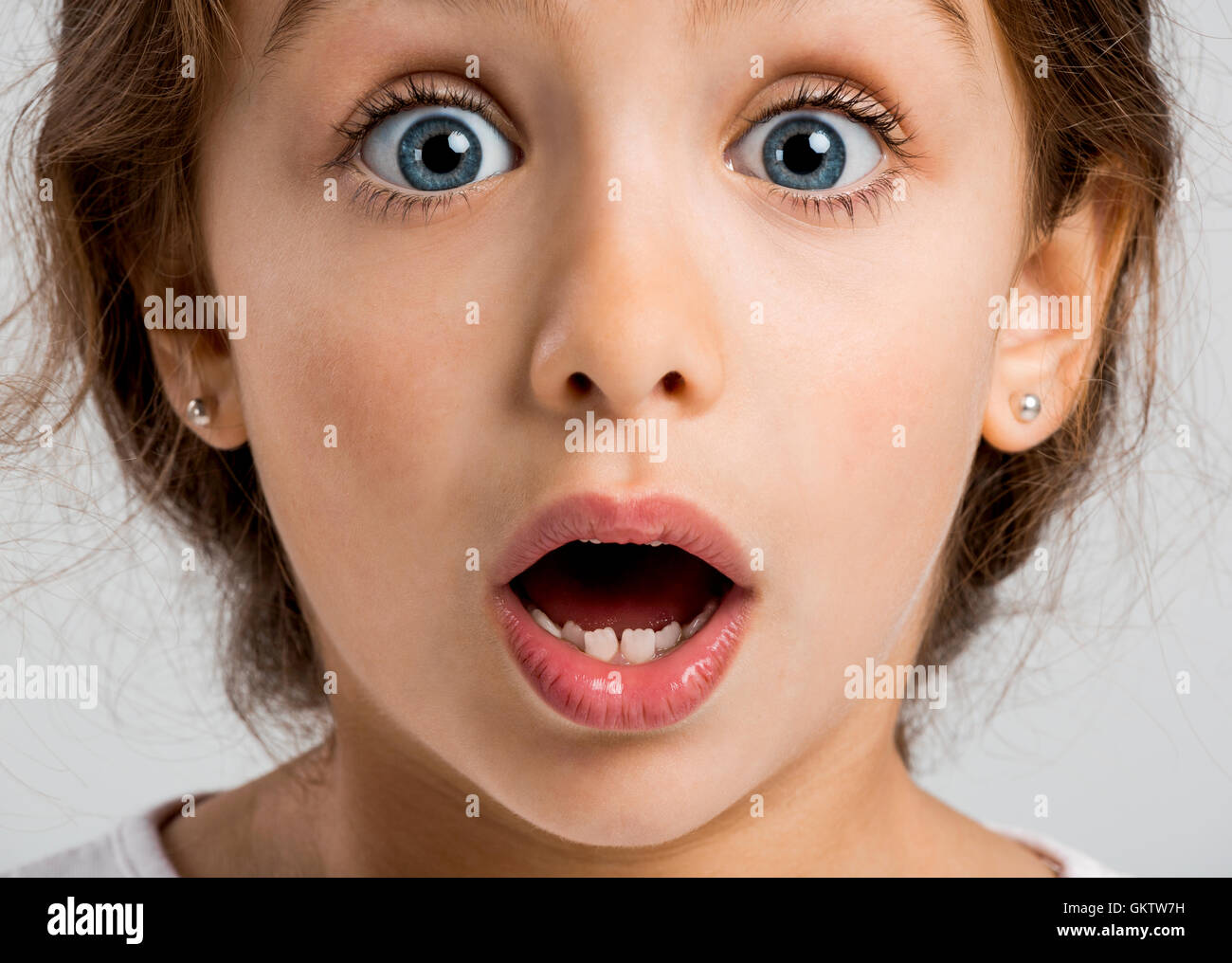Studio portrait of a happy little girl with a astonished expression Stock Photo
