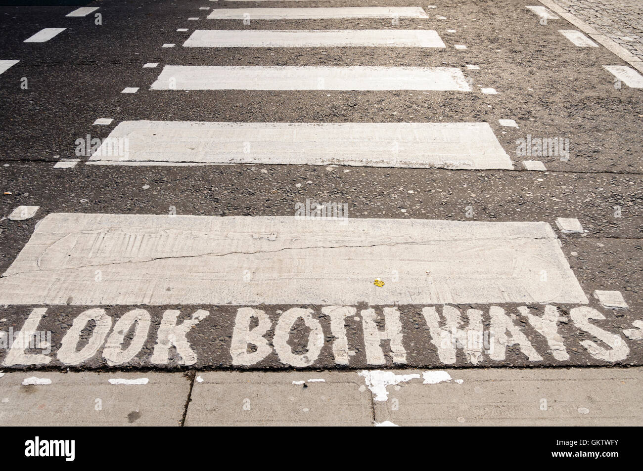 Road warning markings to look both ways at a London pedestrian crossing. Stock Photo