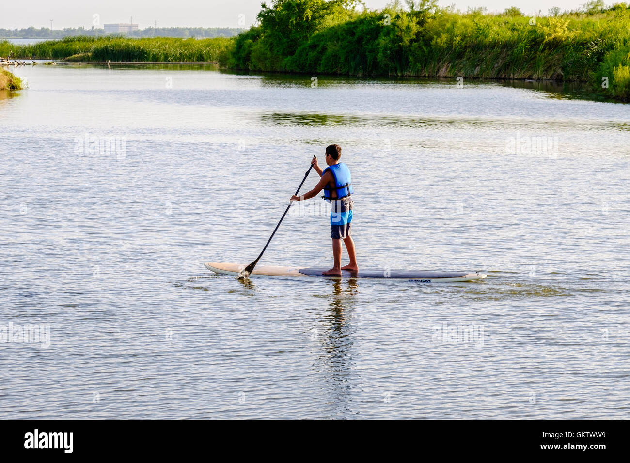 A 12-14 year old Caucasian boy on a paddle board on the North Canadian  river near Bethany and Oklahoma City, Oklahoma, USA Stock Photo - Alamy