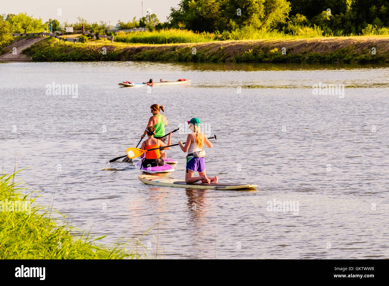 5 people enjoy paddleboarding on the North Canadian river next to Overholser lake in Oklahoma, USA. Stock Photo