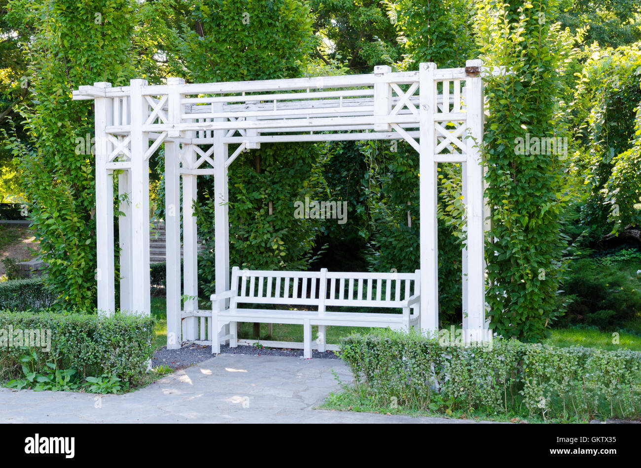 A beautiful gazebo and a bench painted in white in a park Stock Photo ...