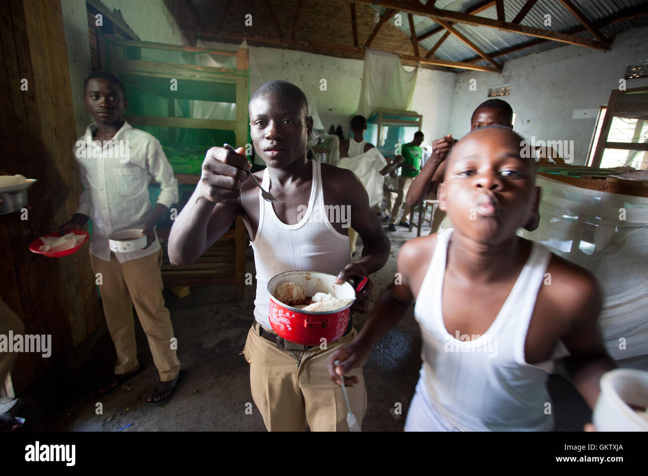 A group of boys eat lunch inside their living quarters at school in Uganda Stock Photo