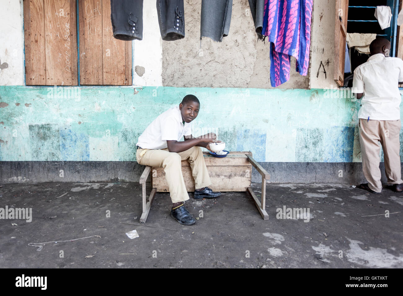 A student eats lunch during a break in studies at a school in Uganda Stock Photo