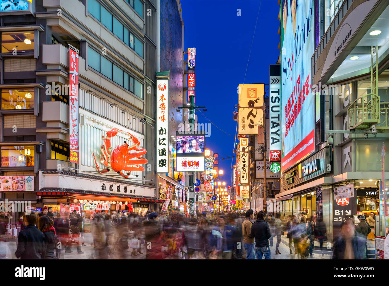 OSAKA, JAPAN - NOVEMBER 25, 2012: Crowds walk below the signs of Dotonbori. With a history reaching back to 1612, the district i Stock Photo