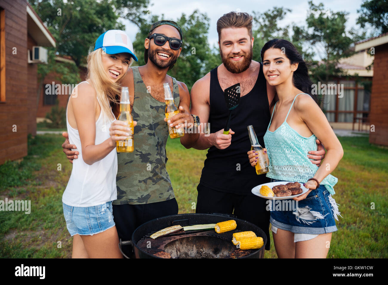 Group of happy smiling friends drinking beer and having barbecue ...