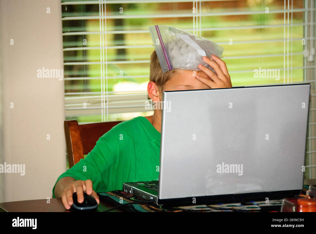 Boy on laptop stressed with headache Stock Photo - Alamy